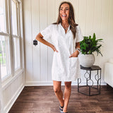 Lined cream denim-like short shift dress with V neck and collar, short sleeves,, contrasting tan stitching, front pocket and eyelet details throughout