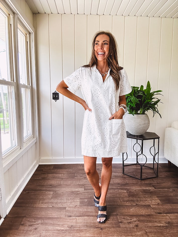 Lined cream denim-like short shift dress with V neck and collar, short sleeves,, contrasting tan stitching, front pocket and eyelet details throughout