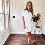 Lined cream denim-like short shift dress with V neck and collar, short sleeves,, contrasting tan stitching, front pocket and eyelet details throughout