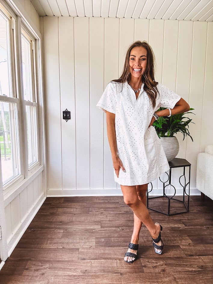Lined cream denim-like short shift dress with V neck and collar, short sleeves,, contrasting tan stitching, front pocket and eyelet details throughout