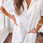 Lined cream denim-like short shift dress with V neck and collar, short sleeves,, contrasting tan stitching, front pocket and eyelet details throughout
