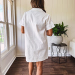 Lined cream denim-like short shift dress with V neck and collar, short sleeves,, contrasting tan stitching, front pocket and eyelet details throughout