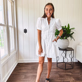 Fully lined white button down front dress with mock neck, V neck, short puffed sleeves, front pocket and elastic bands at the waist for a cinched waist look.