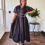 Black cotton maxi dress with white piping, collar, puff sleeve, scalloped hem, lined skirt and button down front.