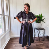 Black cotton maxi dress with white piping, collar, puff sleeve, scalloped hem, lined skirt and button down front.