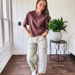 Mineral washed light olive denim barrel pants with carpenter design, side pockets and button and zipper closure with elastic back waist.