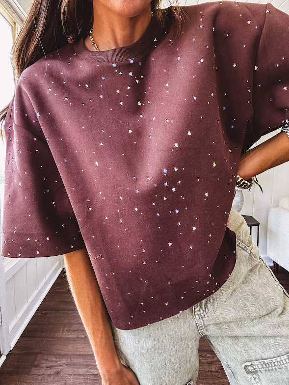 Cotton brown tee with a boxy cut and tie dyed underlayment peeking out of star cutouts, adorned with multicolor mini crystals.