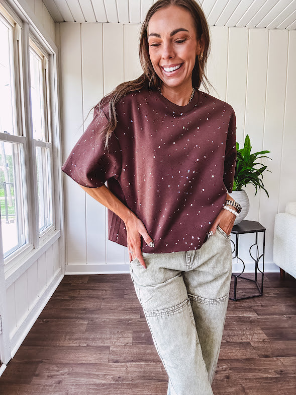 Cotton brown tee with a boxy cut and tie dyed underlayment peeking out of star cutouts, adorned with multicolor mini crystals.