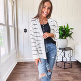 Soft, popcorn textured white cardigan with black striping and side pockets.
