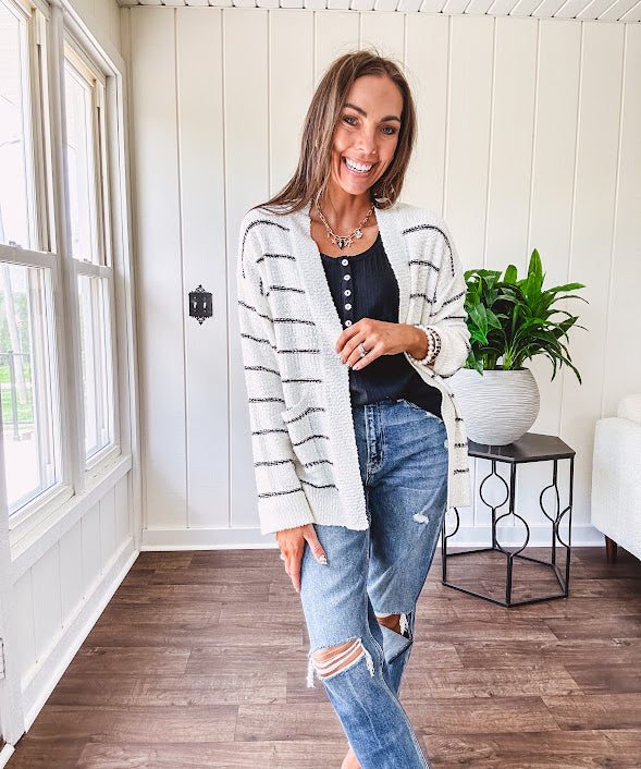 Soft, popcorn textured white cardigan with black striping and side pockets.