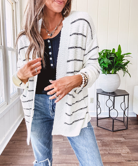 Soft, popcorn textured white cardigan with black striping and side pockets.