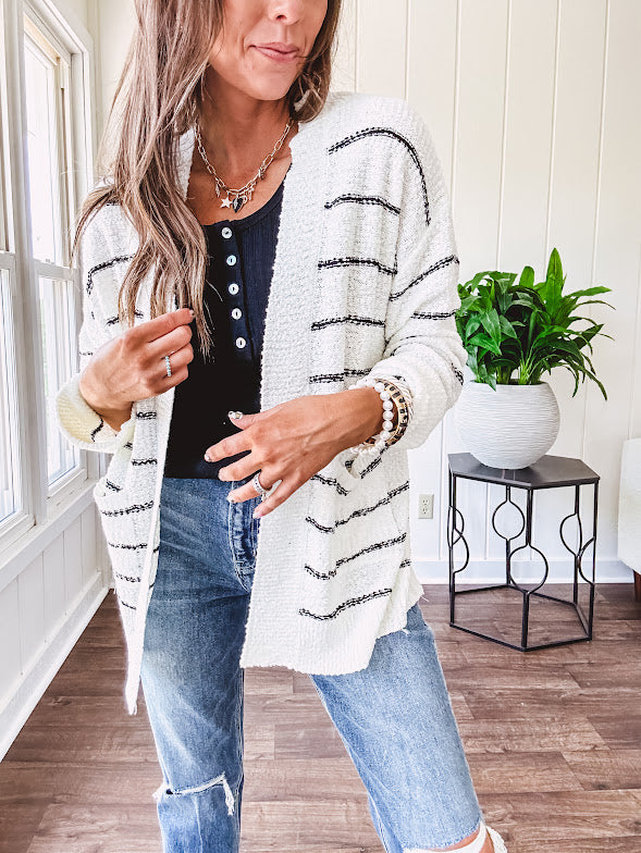 Soft, popcorn textured white cardigan with black striping and side pockets.