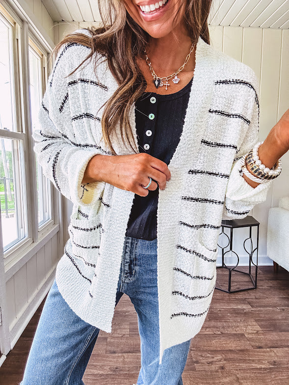 Soft, popcorn textured white cardigan with black striping and side pockets.