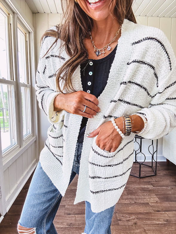 Soft, popcorn textured white cardigan with black striping and side pockets.