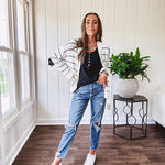 High rise stretch medium wash denim in a mom jean style with distressing at the knees and ankles, skinny design.
