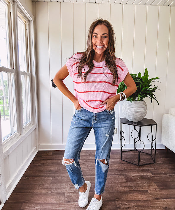 High rise stretch medium wash denim in a mom jean style with distressing at the knees and ankles, skinny design.