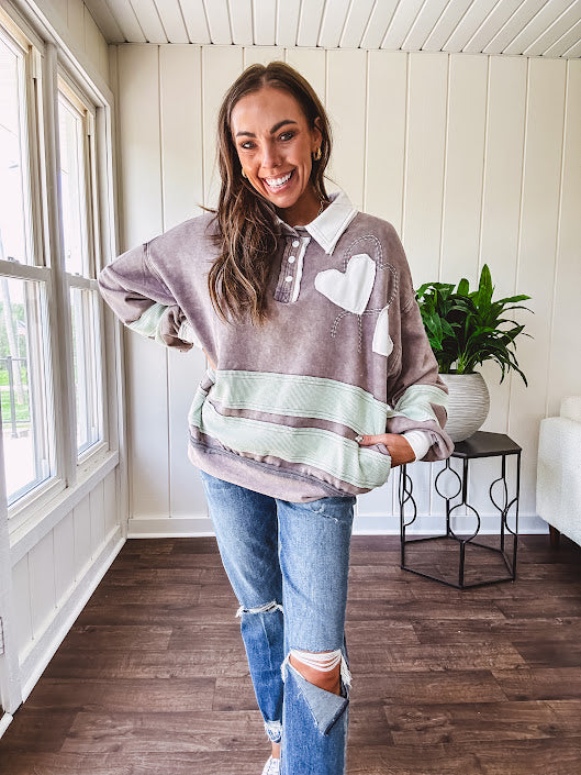 Washed terry knit slate grey pullover with white collar, and 3 snap button placket and heart patchwork and embroidery with Rugby style waffle texture striping detail and pockets.