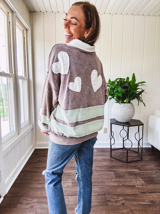 Washed terry knit slate grey pullover with white collar, and 3 snap button placket and heart patchwork and embroidery with Rugby style waffle texture striping detail and pockets.