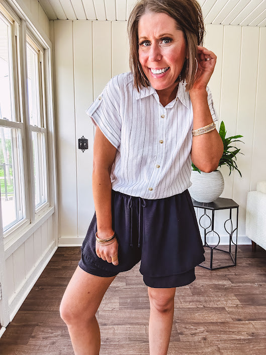 Thin, flowy black shorts with elastic drawstring waist and double layer hemline.