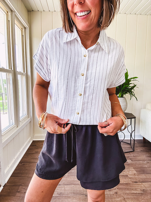 Thin, flowy black shorts with elastic drawstring waist and double layer hemline.