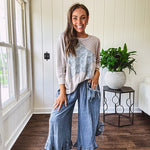 Light wash Tencel bloomer style pants with elastic, smocked waist band, front pockets with bow details and ruffled, angled hem.
