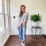 Light wash Tencel bloomer style pants with elastic, smocked waist band, front pockets with bow details and ruffled, angled hem.