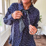 Navy gauze button down long sleeved top featuring a ruffled hem, front pocket and matching navy paisley scarf tie.