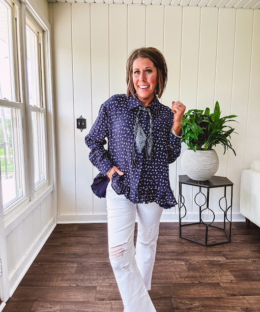 Navy gauze button down long sleeved top featuring a ruffled hem, front pocket and matching navy paisley scarf tie.
