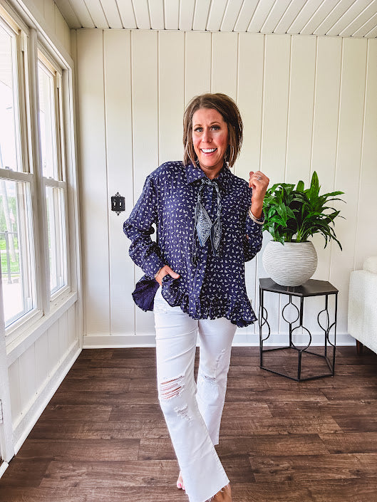 Navy gauze button down long sleeved top featuring a ruffled hem, front pocket and matching navy paisley scarf tie.