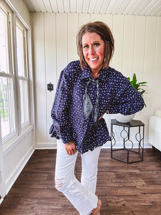 Navy gauze button down long sleeved top featuring a ruffled hem, front pocket and matching navy paisley scarf tie.