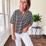 Black and white striped boxy cut Henley style knit top with 4 wooden buttons at the V neck, front pocket, short sleeves and shorter U shaped hem.
