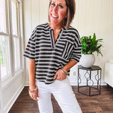 Black and white striped boxy cut Henley style knit top with 4 wooden buttons at the V neck, front pocket, short sleeves and shorter U shaped hem.