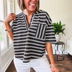 Black and white striped boxy cut Henley style knit top with 4 wooden buttons at the V neck, front pocket, short sleeves and shorter U shaped hem.