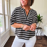 Black and white striped boxy cut Henley style knit top with 4 wooden buttons at the V neck, front pocket, short sleeves and shorter U shaped hem.