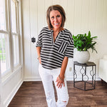 Black and white striped boxy cut Henley style knit top with 4 wooden buttons at the V neck, front pocket, short sleeves and shorter U shaped hem.