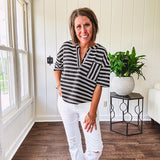 Black and white striped boxy cut Henley style knit top with 4 wooden buttons at the V neck, front pocket, short sleeves and shorter U shaped hem.