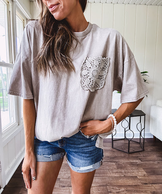 100% cotton faded tee with a crochet front pocket, split hem and oversized fit.