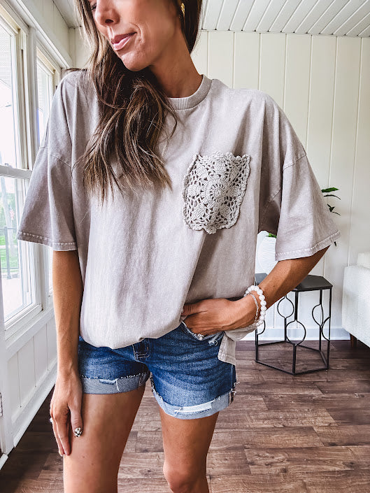 100% cotton faded tee with a crochet front pocket, split hem and oversized fit.