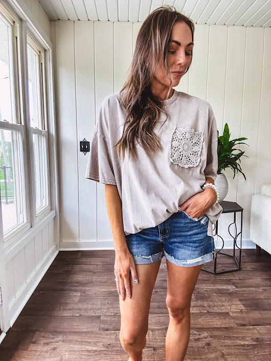 100% cotton faded tee with a crochet front pocket, split hem and oversized fit.