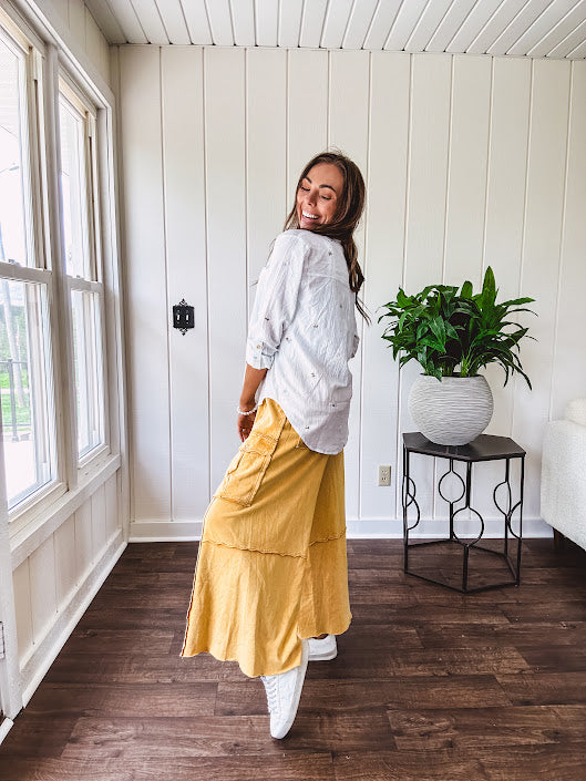 Washed mustard colored wide leg terry knit pants with a raw hem and elastic drawstring waist and oversized pockets.