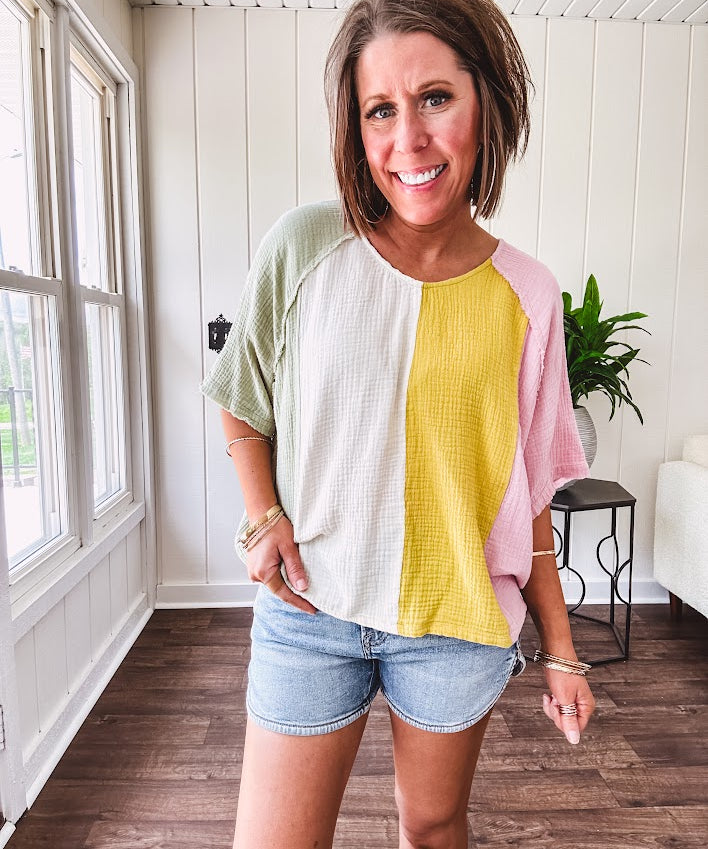 Oversized gauze dolman style top with modest V neck and vertical color blocking with pastel sage, cream, mustard and pink, exposed seams.