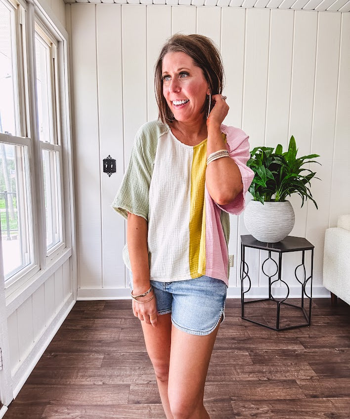 Oversized gauze dolman style top with modest V neck and vertical color blocking with pastel sage, cream, mustard and pink, exposed seams.