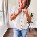 Soft, woven sweater vest with cap sleeves and faux wooden buttons down the front available in cream, sage and blush.