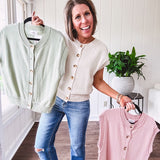 Soft, woven sweater vest with cap sleeves and faux wooden buttons down the front available in cream, sage and blush.