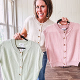 Soft, woven sweater vest with cap sleeves and faux wooden buttons down the front available in cream, sage and blush.