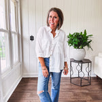 White, nearly sheer long sleeved button down with two front pockets, faux wooden buttons down the front and an oversized fit.