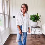 White, nearly sheer long sleeved button down with two front pockets, faux wooden buttons down the front and an oversized fit.