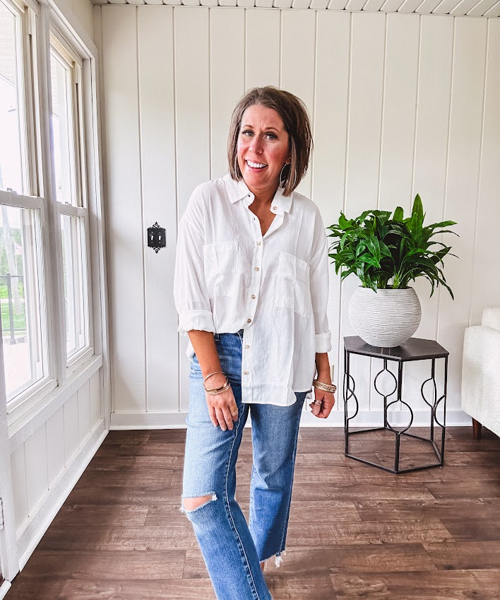 White, nearly sheer long sleeved button down with two front pockets, faux wooden buttons down the front and an oversized fit.