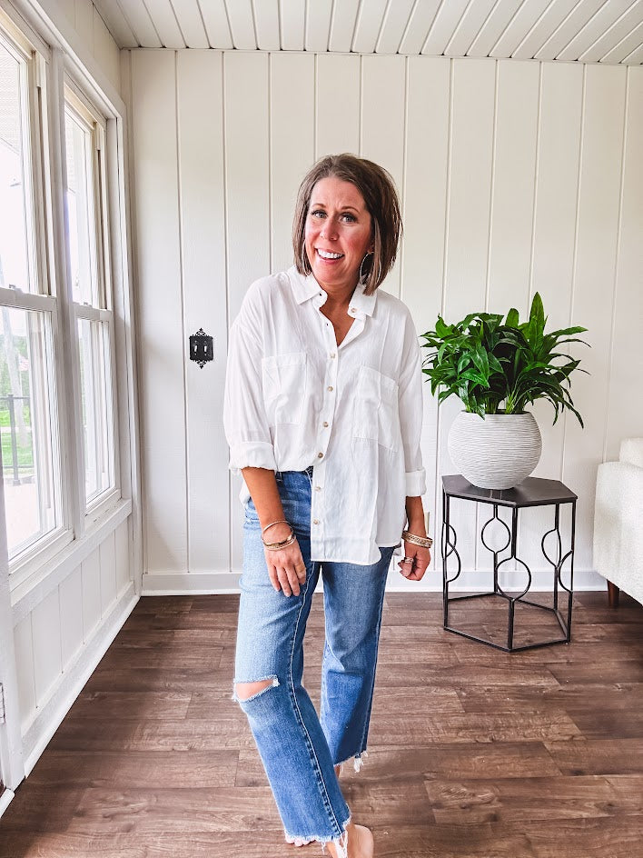White, nearly sheer long sleeved button down with two front pockets, faux wooden buttons down the front and an oversized fit.
