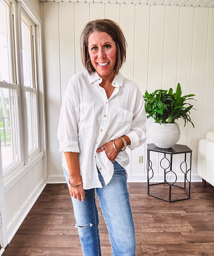 White, nearly sheer long sleeved button down with two front pockets, faux wooden buttons down the front and an oversized fit.
